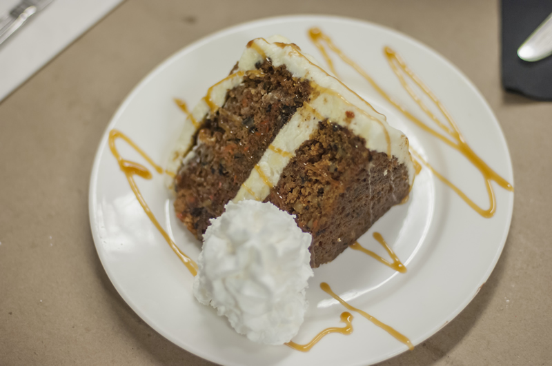 a slice of carrot cake with a caramel drizzle