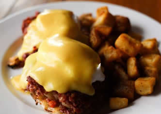 english muffin topped with Canadian bacon, two poached eggs and hollandaise