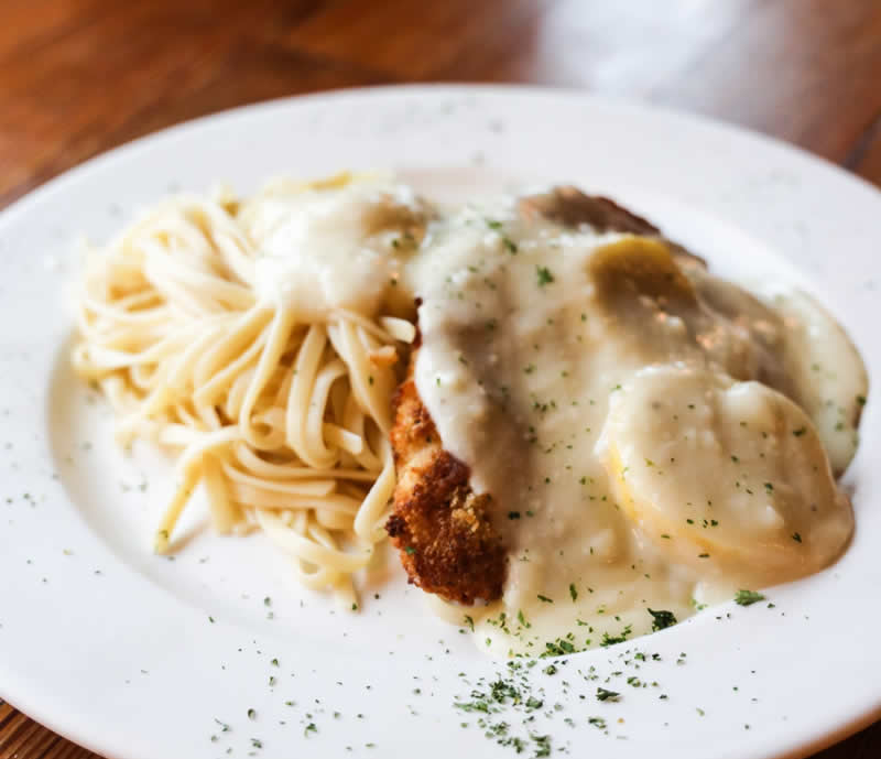 A plate of Lemon Chicken, crispy breaded chicken served over linguine with a lemon cream sauce